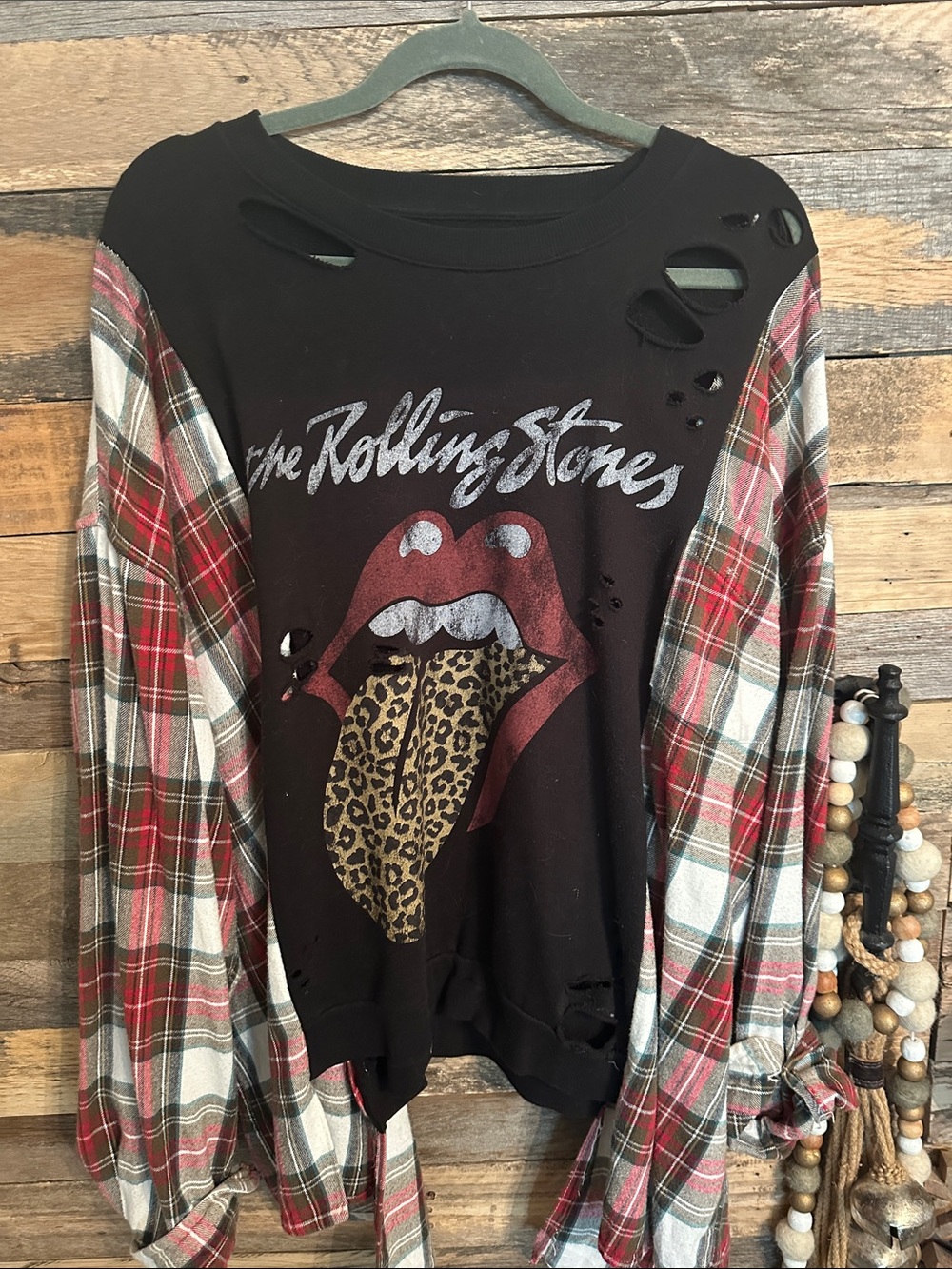 the Rolling Stones Black Pullover with Red Plaid Sleeves poncho over head